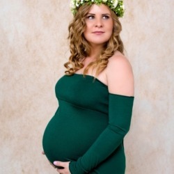 Kobeta w zielonej sukience w wienku we włosach na sesji ciążowej
